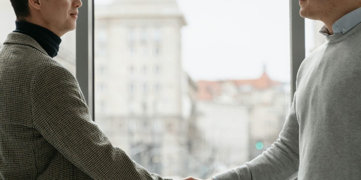 A confident person shaking hands, symbolizing a successful financing agreement or investment deal.