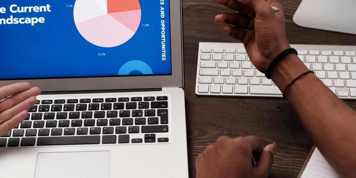 A person intently analyzes data on a chart, seeking undervalued properties and market opportunities.